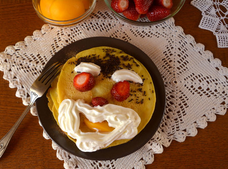 Sweet homemade pancakes with apricots, strawberries, chocolate and whipped cream.の写真素材