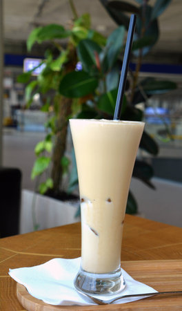 Frappe coffee with ice on a glass on a wooden table