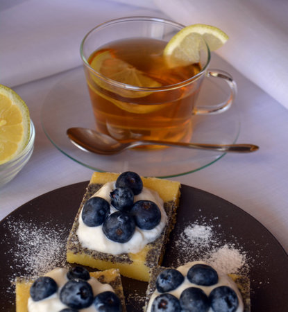 Summer dessert with ground poppy, blueberries and cottage cheese and cup of tea.の写真素材