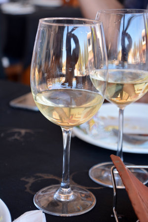 Celebration with two glasses of white wine on a black background on a restaurant.の写真素材