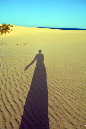 Shadow of woman on the beach Corralejo, Fuerteventura,Canary Islands, Spainの写真素材