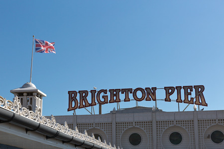 Brighton Pier signage with an English flag on the roof on a sunny day with no clouds in the skyのeditorial素材