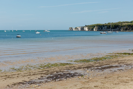A photo taken on a spring day at Swanage beach looking towards the boats on the sea and the coast lineの写真素材