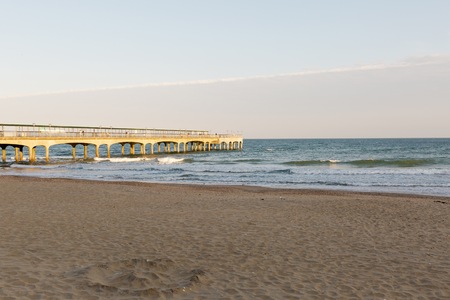Golden sunset light at the beach at a pier in Europe on a summer dayのeditorial素材