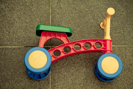 A top view of a child bicylcle made in plastic on stone tiles photo with an applied vintage filterのeditorial素材