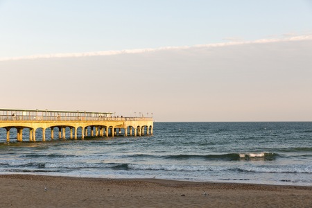 Golden sunset light at the beach at a pier in Europe on a summer dayのeditorial素材