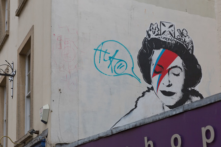 April 2014 - Bristol, United Kingdom: A graffiti of the Royal Queen with red and blue  lightning shaped make to the right closed eye. Colston Street, BH2 8DJ, Banksy art, Royal Queenのeditorial素材