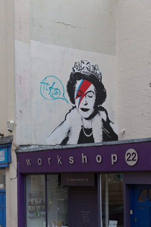 April 2014 - Bristol, United Kingdom: A graffiti of the Royal Queen with red and blue  lightning shaped make to the right closed eye. Colston Street, BH2 8DJ, Banksy art, Royal Queenのeditorial素材