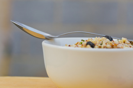 A bowl of delicious fresh quinoa and bulgar weat  with parsley, walnuts, goji berries and blue berries, sprinkled with olive oil and lemon juiceの写真素材