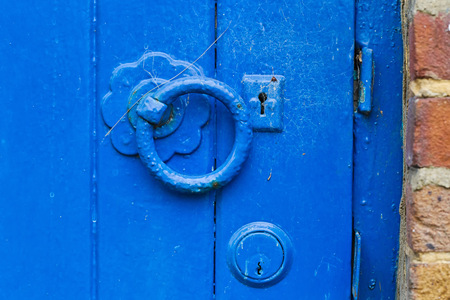 A metal blue painted latch on a blue painted wooden doorのeditorial素材