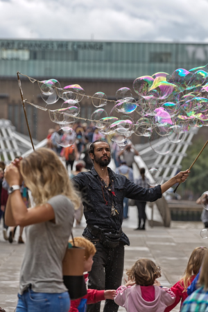 London, UK - July 2016:  Bubbles from a street entertainer, with St Paul's Cathedral in the background, on the South Bank Londonのeditorial素材