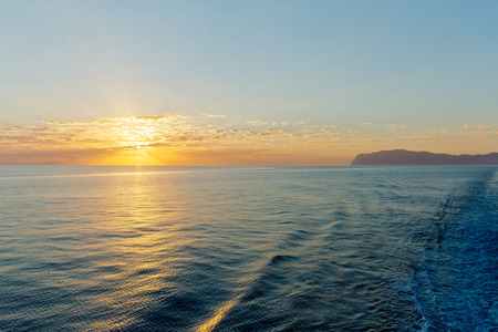 Looking back towards Amorgos Island, Greece, seeing a beautiful seascape with deep ocean waters and sunrise cloudscapeの写真素材