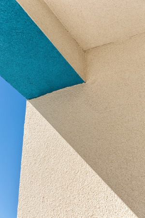Architectural Corner detail of modern white and blue rendered building with blue skyの写真素材