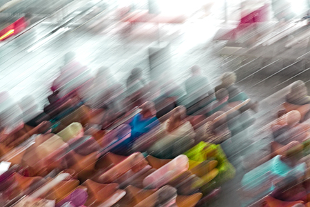 Picture with camera made motion blur effect of a crowd of people sitting downの写真素材