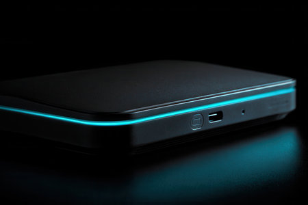Close-up of a black tech device with a glowing blue LED edge, conveying innovation, connectivity, and modern design. AI generated.の素材