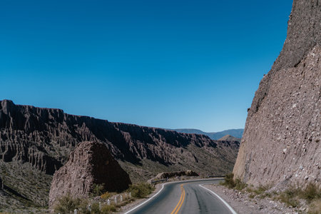 A road with a mountain in the background. The road is empty and the sky is clearの写真素材