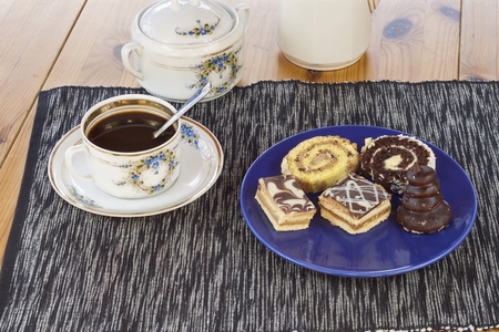 dessert with coffee chocolate cakes and rolls on the table blurred backgroundの写真素材