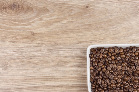 coffee beans in a porcelain bowl on wooden background spilled coffee beans coffee mugの写真素材