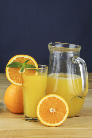Domestic fresh orange juice in a glass jar on a wooden table.の写真素材