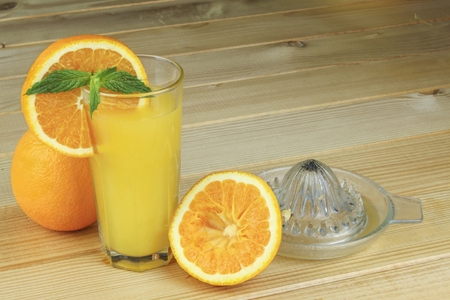 Domestic fresh orange juieu on a wooden table.の写真素材