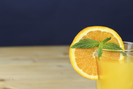 Domestic fresh orange juieu on a wooden table.の写真素材