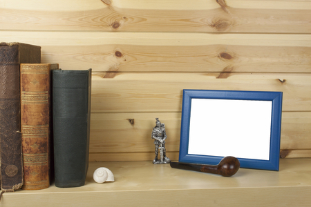 wooden shelf with old books and picture frame for your text.の写真素材