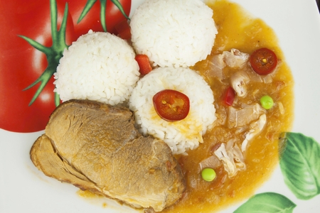 Slice roast pork with rice and sauce. Preparing homemade food. Delicious homecooked meal for one person.の写真素材