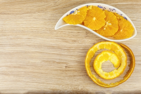 peeled and sliced orange in a porcelain bowl on the table.の写真素材