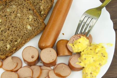 Poultry sausages on a wooden table, preparing home-made snacks. Ingredients for seasoning sausages.の写真素材