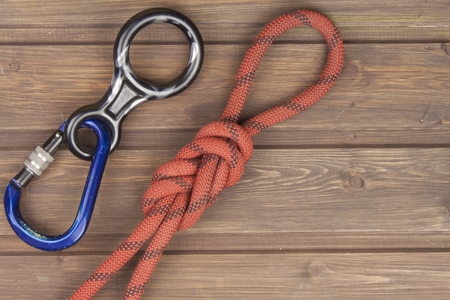 Figure eight knot with climbing carabiner and rappel eight on wooden background. The concept of selling advertising space for climbing equipment.の写真素材