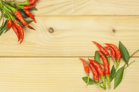 Freshly picked chili peppers on a wooden table. Preparation for the domestic processing of a crop. Decoration of chilli peppers. Place for text menu. Healthy fresh food.の写真素材