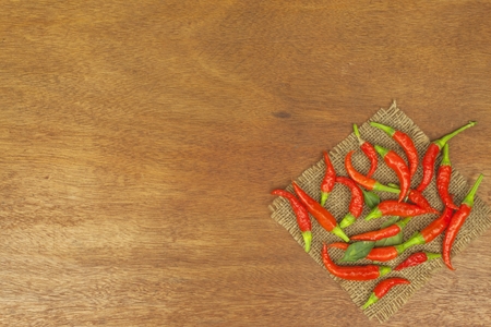 Freshly picked chili peppers on a wooden table. Preparation for the domestic processing of a crop. Decoration of chilli peppers. Place for text menu. Healthy fresh food.の写真素材