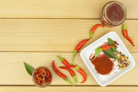 Spices in a ceramic bowl. Freshly picked chili peppers on a wooden table. Preparation for the domestic processing of a crop. Decoration of chilli peppers. Place for text menu. Healthy fresh food.の写真素材
