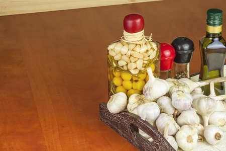 Spices and ingredients to prepare meat for grilling. Garlic, aromatic ingredients for flavoring food. Home remedy for colds and flu. Garlic marinated in olive oil. Seasoning food.の写真素材