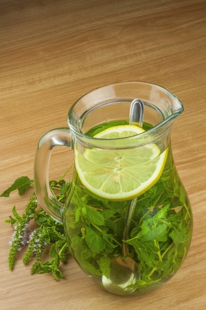 Fresh homemade mint tea. Tempting summer refreshment. Healthy, refreshing drink without sugar. Peppermint tea in a glass jar with lemon. Preparing tea.の写真素材