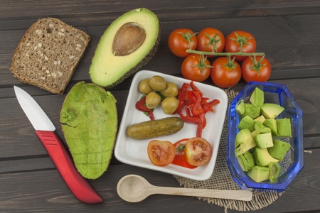 Preparation of dietary avocado salad. Fresh ripe avocado on a wooden background. Food background...