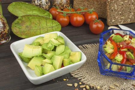 Preparation of dietary avocado salad. Fresh ripe avocado on a wooden background. Food background...