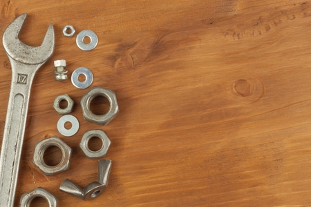 Disorder in the tool. Preparing for home treatment. Various tools, screws and nuts on a wooden...