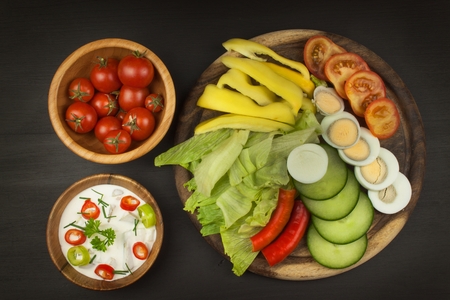 Fresh vegetables for snacks with dressing. Dip for vegetables. Healthy diet meal for dinner. Preparing vegetables in a home kitchen.の写真素材