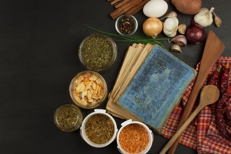 Cookbook and spices on wooden table. Cookbook and ingredients. Garlic, chili peppers and onion. Ingredients for cooking. Home Kitchen.の写真素材