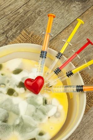 Moldy pudding and syringe. Treatment of the disease. Mold and antibiotics. Poisonous food full of mold. Unhealthy food. Spores of the fungus for food. Growing mold.の写真素材