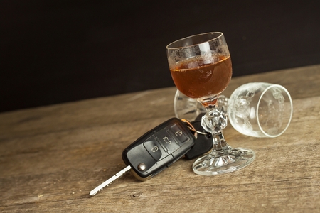 Alcohol and driving. Danger on the roads. Alcoholic behind the wheel. Car keys on the bar