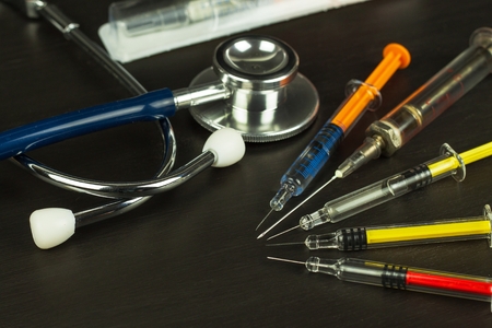 Syringe on a wooden board. Cancer treatment. Flu vaccination. Medical Instruments and Phonendoscope.