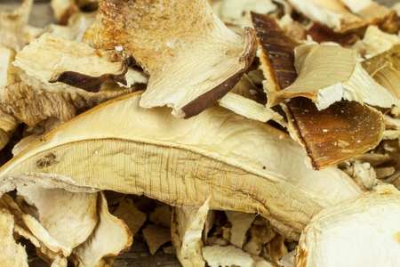 Dried mushrooms in a wooden table. Pile of dried edible mushrooms for sale