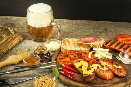 Grilled sausage with mustard on a wooden cutting board. Summer barbecue party. Fat mealの写真素材