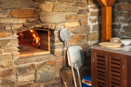 Home outdoor stone pizza oven. Traditional pizza production. Preparation of dinner