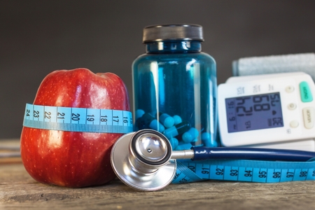Red apple with measuring tape to measure length. Treatment of obesity and diabetes, measurement of...