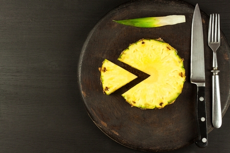 Sliced pineapple on the kitchen table. Diet food. Vitamins against influenzaの写真素材