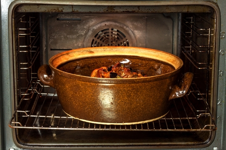 Electric domestic oven and ceramic pot. Baking dishes for meat. Preparation of food in the ovenの写真素材