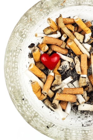 Cigarettes in a glass ashtray on a white background. Treatment of lung cancer. Tobacco industryの写真素材